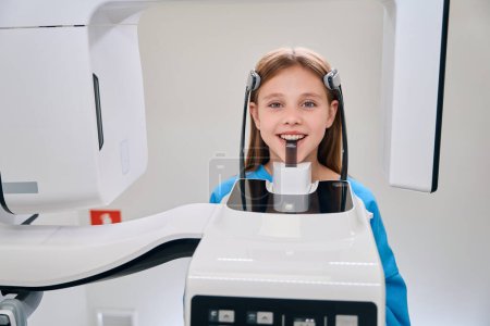 Téléchargez les photos : Enfant soumis à une procédure de radiographie dentaire, l'équipement moderne est utilisé - en image libre de droit