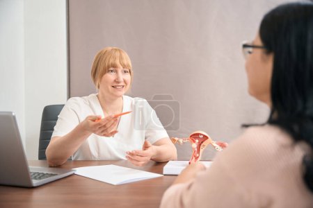 Photo for Smiling doctor gynecologist listening to female patient, happy of regulation of periods and hormonal level, appointment at reproductology centre, female health check-up - Royalty Free Image