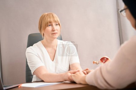 Photo for Caring female practitioner listening to patient story tightly holding her hands, supporting and empathising hearing news about miscarriage, healthcare and medicine - Royalty Free Image
