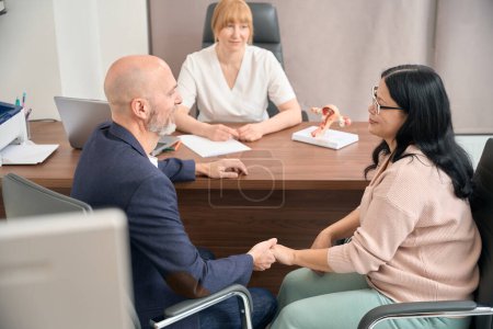 Photo for Mature married couple visiting gynecologist office, going to health check-up before planning pregnancy, preparation to artificial fertilization - Royalty Free Image