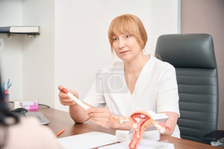 Photo for Woman gynecologist holding and showing special syringe with hormones, special therapy for women before in-vitro fertilization, reproductology clinic - Royalty Free Image