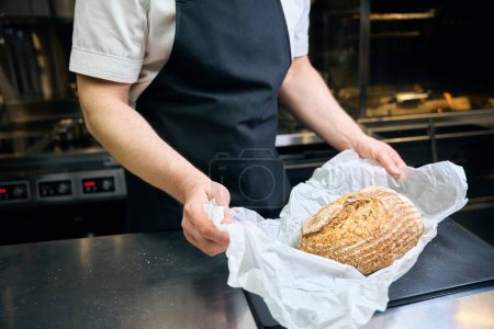 Téléchargez les photos : Chef masculin partiel préparant le pain pour la cuisson sur la planche à découper à table sur la cuisine dans le restaurant. Concept de délicieuse alimentation saine - en image libre de droit