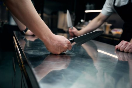 Foto de Chefs masculinos de competición con cuchillos de pie en la mesa en la cocina en el restaurante. Concepto de sabrosa alimentación saludable - Imagen libre de derechos