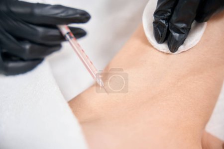 Photo for Close up partial view of female cosmetologist doing armpit beauty injection with syringe of woman in beauty salon. Body skin care, lifting and rejuvenation - Royalty Free Image