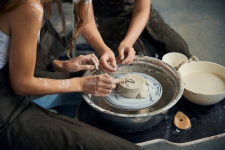 Foto de Mujeres manos alfareros haciendo producto de cerámica en la rueda de cerámica en el estudio creativo - Imagen libre de derechos