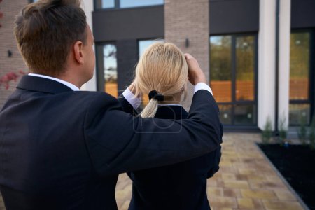 Téléchargez les photos : Homme debout derrière la femme et fermé les yeux avec ses mains pour garder une nouvelle maison secrète - en image libre de droit