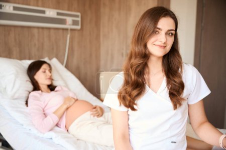 Foto de Médico profesional con paciente embarazada hospitalizada en la habitación del hospital - Imagen libre de derechos