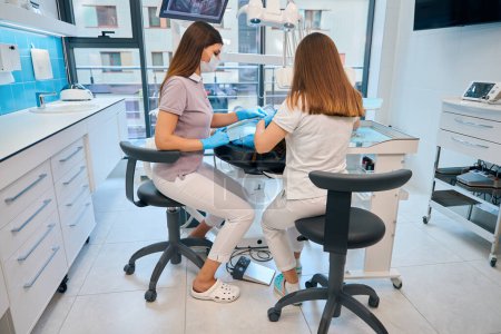 Foto de Doctor con asistente en su lugar de trabajo en un consultorio dental, hay un montón de equipos modernos en la habitación - Imagen libre de derechos