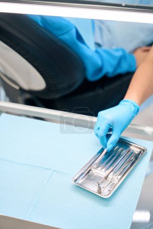 Woman at work in a dental office, she uses sterile instruments