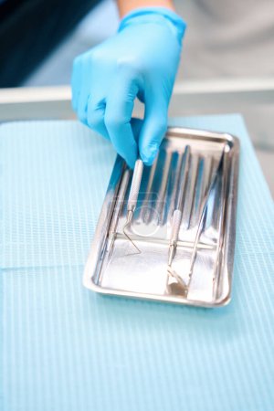 Téléchargez les photos : Hygiéniste dentiste au cabinet dentaire, elle utilise des instruments stériles - en image libre de droit