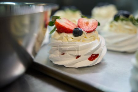 Téléchargez les photos : Vue sur mini dessert Pavlova sucré et savoureux avec merengue croustillante et mousse de fruits frais, avec crème anglaise sur le dessus, inspiration culinaire - en image libre de droit