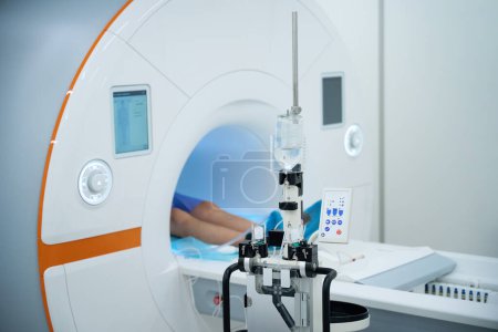 Ausgeschnittenes Foto des Patienten, der im Rückenbereich auf dem Scan-Tisch im MRT-Portal liegt