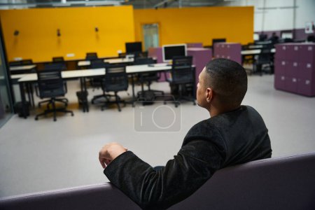Photo for Copy space photo of calm male african american client sitting on sofa in empty cozy office while waiting for consultant - Royalty Free Image