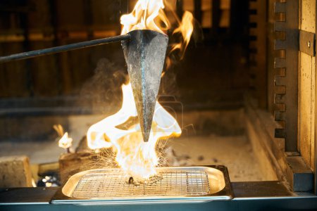 Foto de Flambe técnica de cocción de hierro quemado triángulo olla freír ostra en bandeja de red de hierro en la chimenea en el restaurante. Concepto de deliciosa alimentación saludable - Imagen libre de derechos