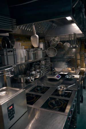 Foto de Interior de la cocina moderna con fuego ardiente en estufa abierta en el fondo en el restaurante. Concepto de sabrosa alimentación saludable - Imagen libre de derechos