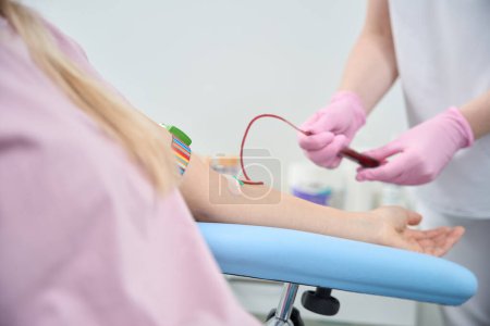 Foto de Terapeuta calificada que conecta un IV, realiza un procedimiento de transfusión de sangre al cliente femenino, administra productos sanguíneos o electrolitos para corregir los desequilibrios electrolíticos, quimioterapia - Imagen libre de derechos