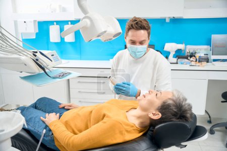 Nervous woman patient feeling relief knowing that the intraoral scanner helping to streamline her dental examination process, high quality dental care in a relaxing environment