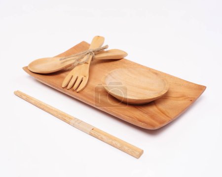 Téléchargez les photos : Cutlery made of wood crafts. An interesting combination of cutlery in the form of an aesthetic placemat, tray, cup, spoon, fork, chopsticks. Utilizing the remaining wood so that it can be useful. - en image libre de droit