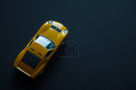 Téléchargez les photos : Jouet en métal voiture de sport de couleur jaune. Vue du haut. Espace de copie. - en image libre de droit