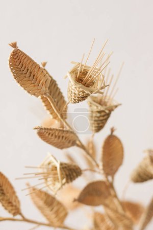 The bouquet flowers is made of straw on a white background. Straw weaving. Small depth of field