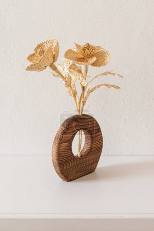 Un jarrón de madera con un ramo de flores hechas de paja. Tejido de paja