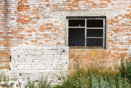 Window of an abandoned house. Brick facade