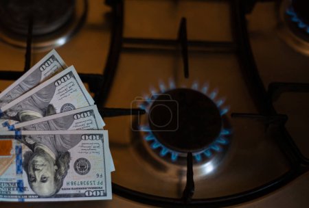 Photo for The banknotes lie next to a burning gas burner. The concept is to increase the cost of supply , payment for natural gas. The energy crisis. High cost, price of gas. - Royalty Free Image