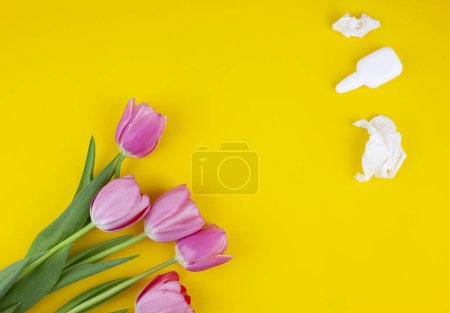 Photo for Allergic sufferer has red eyes, runny nose, stuffy, sore nose, suffering from pollen allergy symptoms, spring fever, hold, flower, plant, tissue, trigger reaction, isolated on pastel yellow studio - Royalty Free Image