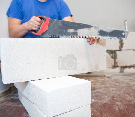 Photo for Hacksaw for aerated concrete. The cutout of the doorway in the wall from the gas block is handmade - Royalty Free Image