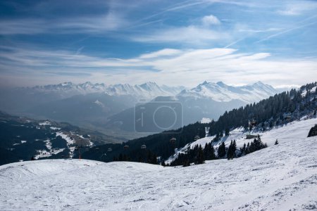 Photo for Snowy mountain peaks with a deep valley and a chairlift in the Austrian Alps. - Royalty Free Image