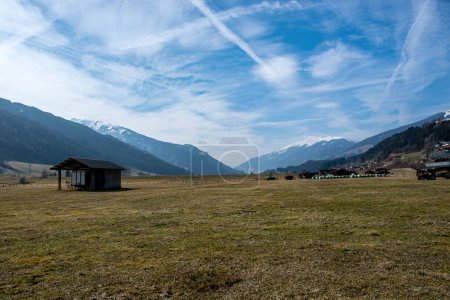 Photo for Valley with meadow surrounded by mountains with snowy peaks and blue sky with lots of cloud in Austrian Alps. - Royalty Free Image