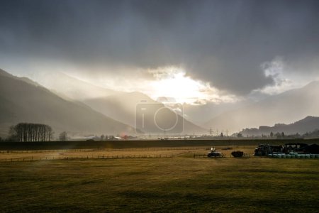 Photo for Sunset in the clouds on a grassy meadow in the mountains in Austria. - Royalty Free Image
