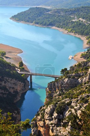 Téléchargez les photos : Le lac de Sainte-Croix bleu turquoise dans le sud de la France en Provence. Eau avec pédales, un pont pour les voitures et de hautes roches au-dessus du lac. - en image libre de droit