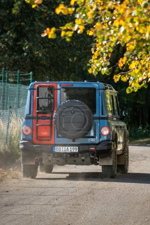 Foto de Brno, República Checa - 6 de octubre de 2023: Vehículo todo terreno Ineos Grenadier en el bosque en un camino de tierra entre los árboles - Imagen libre de derechos