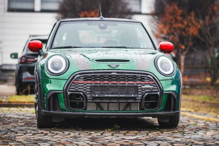 Téléchargez les photos : Brno, République tchèque - 10 novembre 2023 : Petite voiture de sport verte Mini Cooper garée dehors sous la pluie. - en image libre de droit