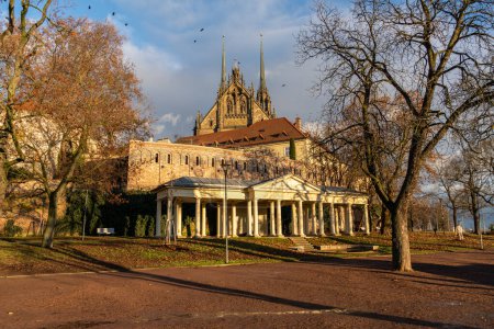 Téléchargez les photos : Brno, République tchèque - 21 décembre 2023 : Un parc urbain avec des arbres, un belvédère avec des colonnes et la cathédrale Pierre et Paul en arrière-plan. - en image libre de droit