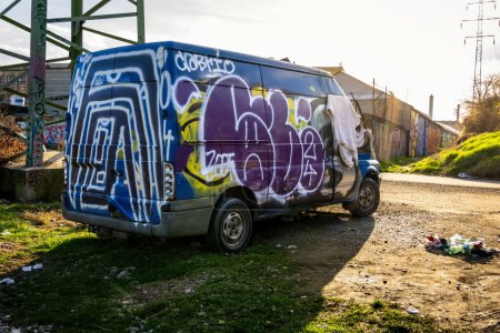 Photo for Brno, Czech Republic - March 12, 2024: Abandoned painted van in an old industrial zone in the city. Street graffiti art. - Royalty Free Image