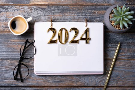 Neujahrsvorsätze 2024 auf dem Schreibtisch. Auflösungsliste 2024 mit Notizbuch, Kaffeetasse auf dem Tisch. Ziele, Vorsätze, Plan, Aktion, Checklistenkonzept. Vorlage New Year 2024, Kopierraum