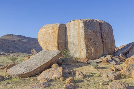 Photo for Giant split boulder in the south Namibian desert landscape under a clear blue sky - Royalty Free Image
