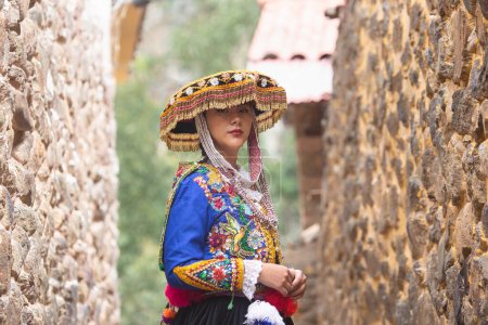 Hermosa chica con vestido tradicional de la cultura andina peruana. Chica joven en la ciudad de Ollantaytambo en el Valle Sagrado de los Incas en Cusco Perú.