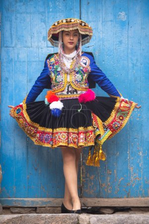 Hermosa chica con vestido tradicional de la cultura andina peruana. Chica joven en la ciudad de Ollantaytambo en el Valle Sagrado de los Incas en Cusco Perú.