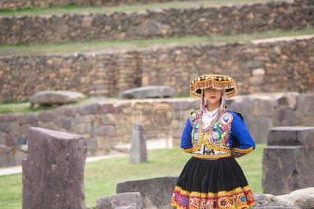 Beautiful girl with traditional dress from Peruvian Andes culture. Young girl in Ollantaytambo city in Incas Sacred Valley in Cusco Peru.