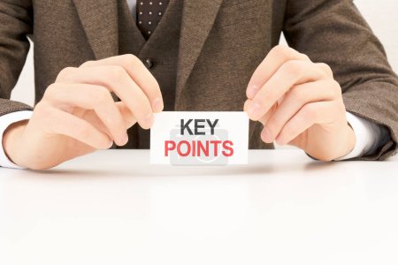 businessman presenting 'KEY POINTS' words on white card.
