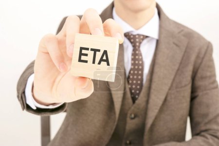businessman hand holding wooden block with the text: eta