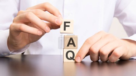 Photo for Faq, frequency asked questions text on cube blocks in businessman hands, white background - Royalty Free Image