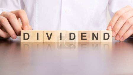 DIVIDEND word made with building cubes, business concept.