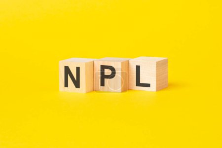 a technical term of NPL on wooden cubes on yellow background, non performing loans