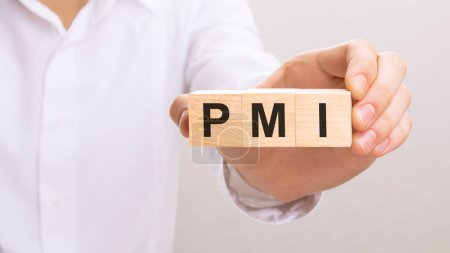 hand holding wood cubes with PMI text. financial, management, economic, business concept.