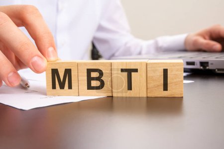 man made word MBTI with wood blocks on the background of the office table. selective focus.