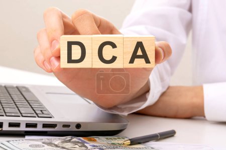 dca - text on wooden cubes, on office table background